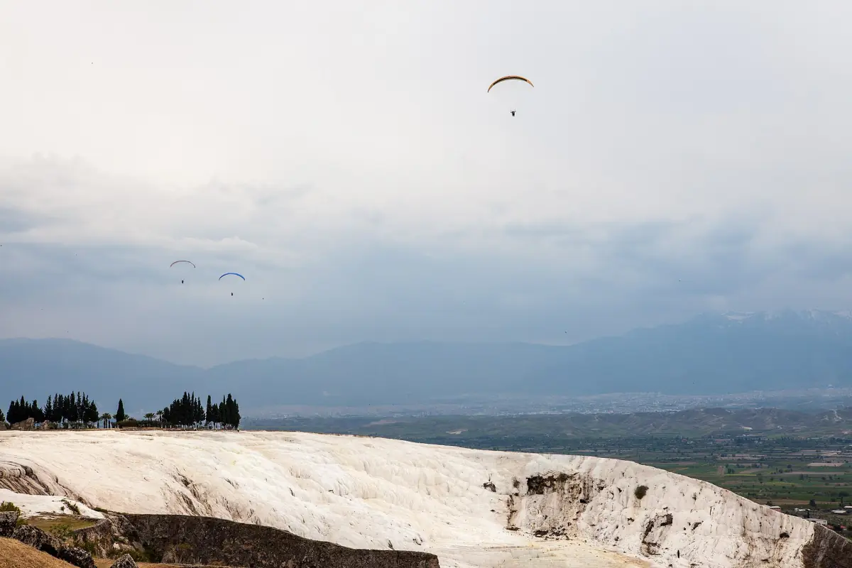 A paraglider above the travertine terraces